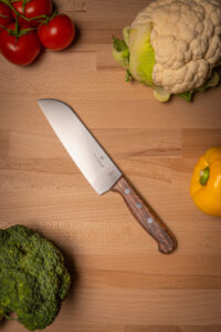 Ein Produktfoto eines Victorinox Messers auf einem Holzbrett mit Gemüse am Rand von Pascal Grüger