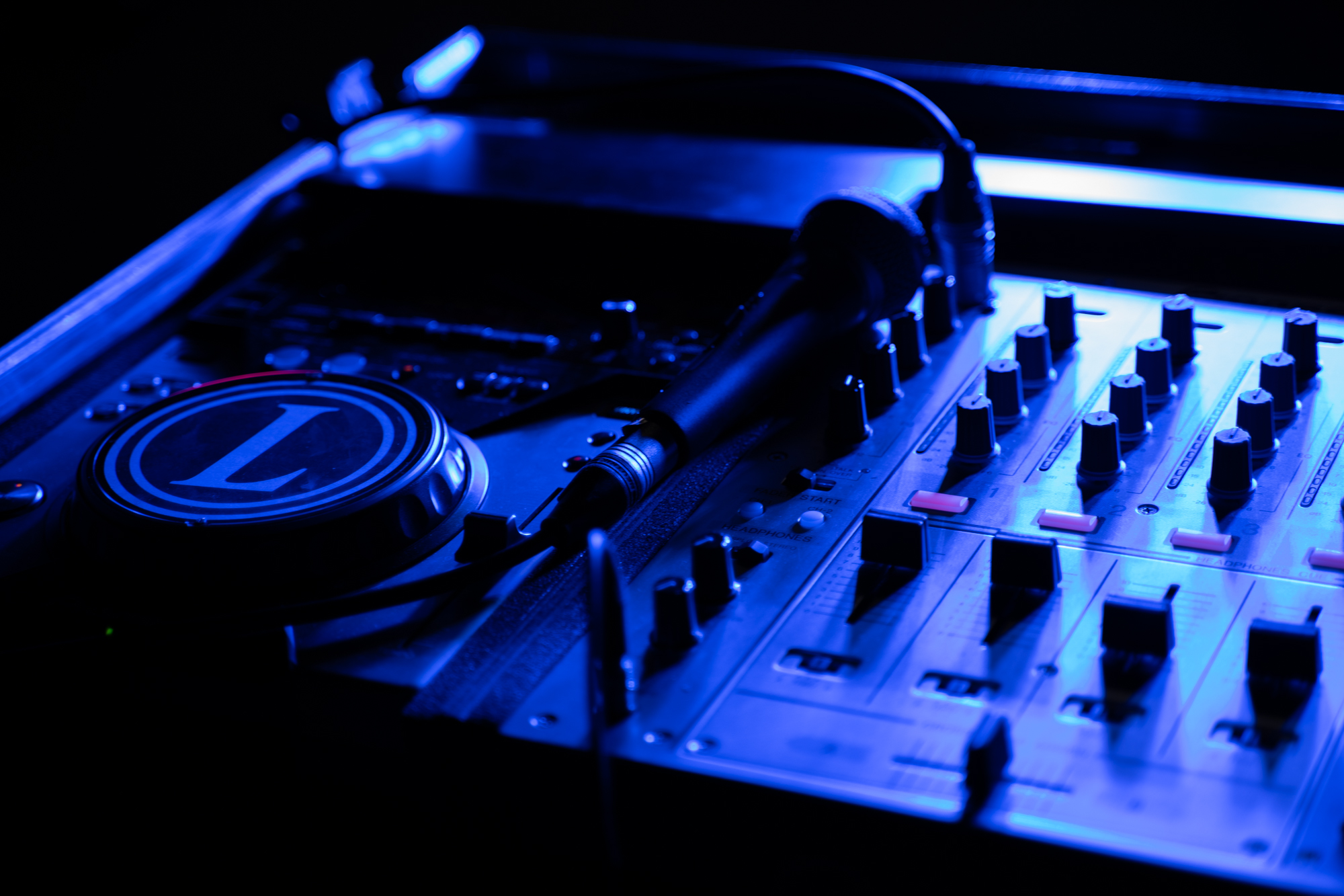 Ein Bild von einem Mischpult und einem SM 58 Mikrofon in blauem Licht vor der Bildbearbeitung